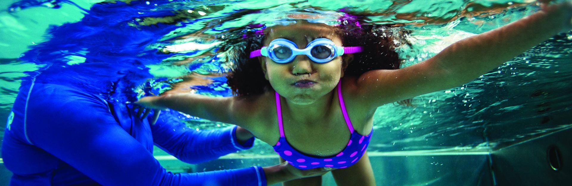 Underwater image of a young girl taking swim lessons