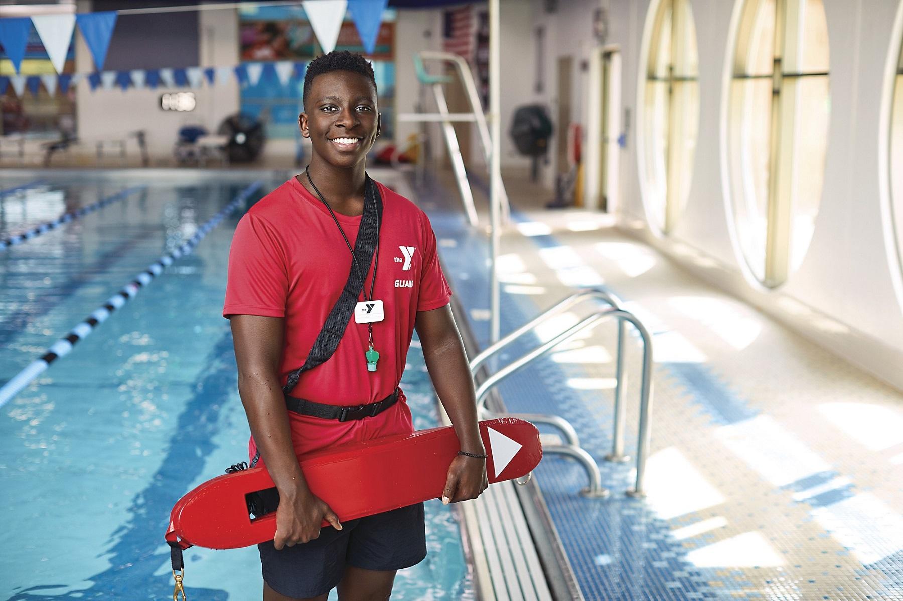 Male lifeguard in red shirt with swim tube